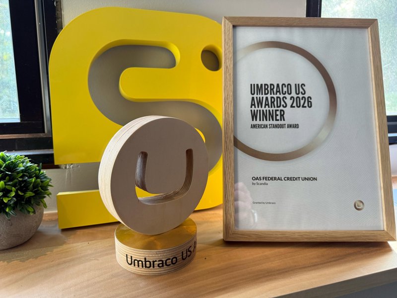 The wooden Umbraco U.S. Awards trophy beside a framed certificate reading Umbraco US Awards 2026 Winner, American Standout Award, OAS Federal Credit Union by Scandia.